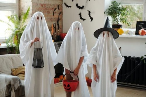 A family cover white sheets as Halloween costumes