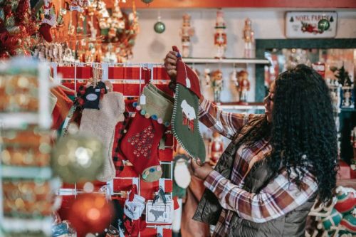 smilling black woman choosing christmas decorations in store
